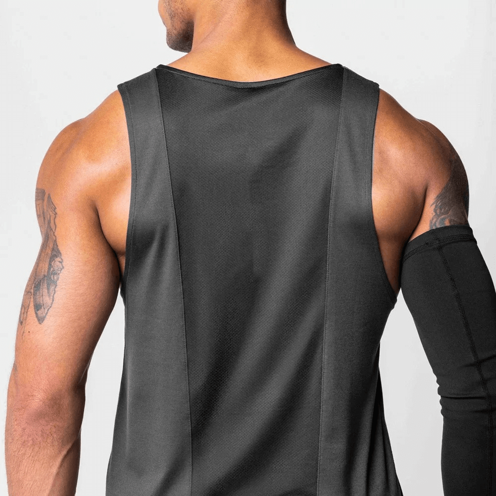 Man wearing a black gym training O-neck tank top with asymmetric hem, showing the back style, made of breathable polyester fabric.